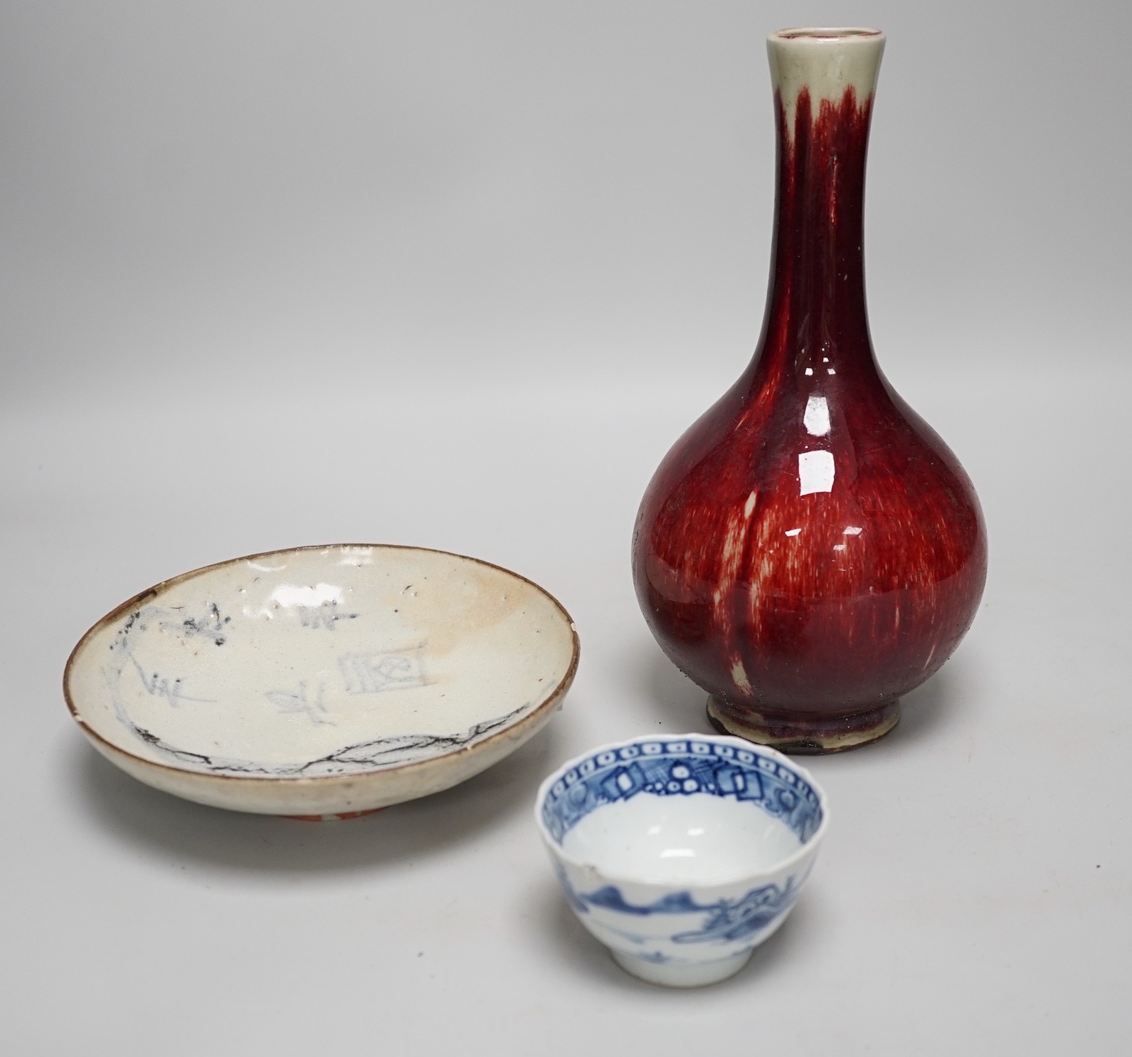 A Chinese sang de boeuf glazed bottle neck vase, together with a Chinese blue and white tea bowl, and a Chinese dish, tallest 23cm